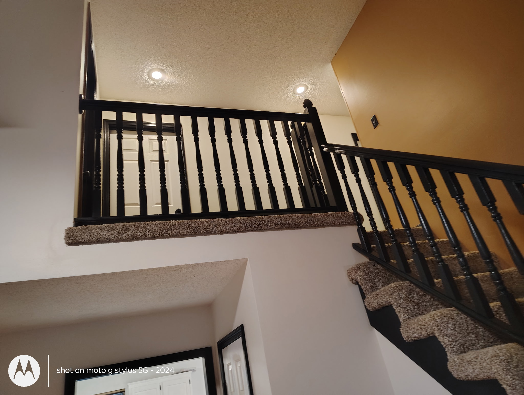 Interior stair landing with black railing and spindles